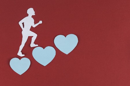 womanizer heartless concept. a paper man is climbing treading on paper hearts.の写真素材