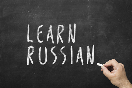 Human hand writing text on blackboard: Learn english.の写真素材