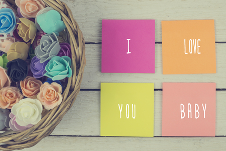 basket of decorative flowers and paper stickers with inscription: I love you baby.Toned.の写真素材