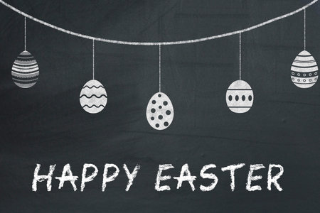 Easter eggs on a black chalkboard with text Happy easter.