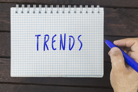 Human hand writing with marker on notepad: Trends.の写真素材