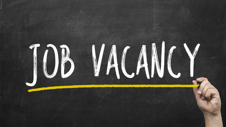 Hand writing Job vacancy on black chalkboard.の写真素材