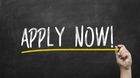 Company manager writing apply now on chalkboard.の写真素材