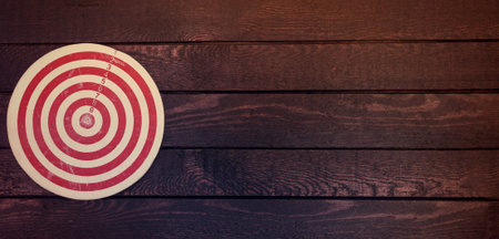 achievements concept. Dart board on dark wooden table. Business concept.の写真素材