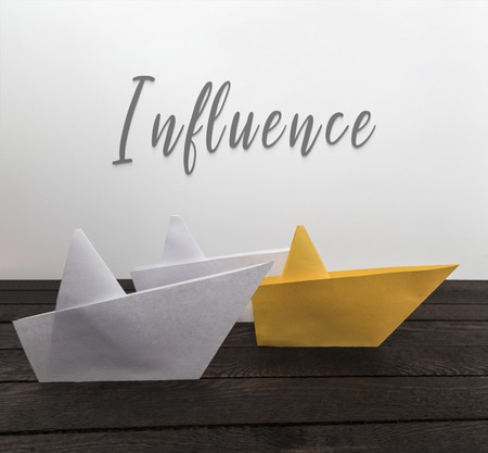 Influence, leadership concept. Paper boats on wood with inscription: Influence. Horizontal viewの写真素材