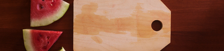 Watermelon pieces and cut board placed on wooden background. Copy space for textの写真素材