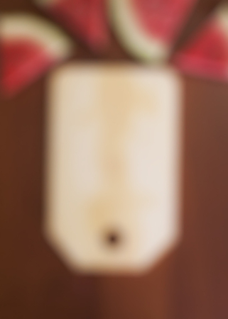 Blurred image of watermelon slices and cutting board on wooden background from high angle. Top view. Copy space.の写真素材