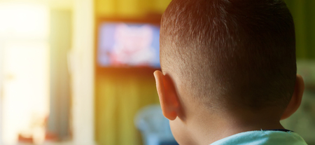 Small boy on the couch watching TV. little Boy watching cartoons on TVの写真素材