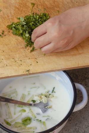 Summer food concept. Summer cold soup. Okroshka. Preparing cold soup with fresh herbs.の写真素材