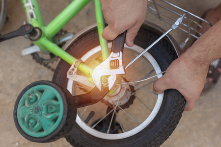 Removing the Training Wheels. Father repairing his kids bicycleの写真素材