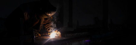 Welder working with metal. worker with protective mask welding metal industry