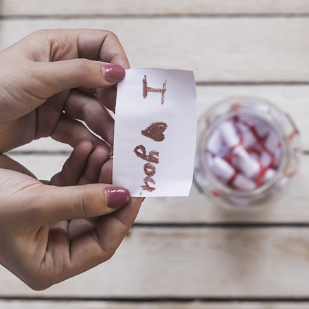 I Love you text on rolled paper. Female opening a gift glass jar with wishes and desires. A gift from her loverの写真素材