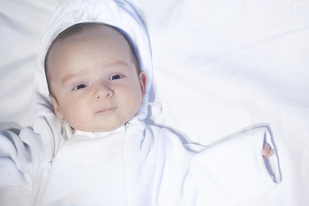 Beautiful newborn baby boy, looking coriously at cameraの写真素材