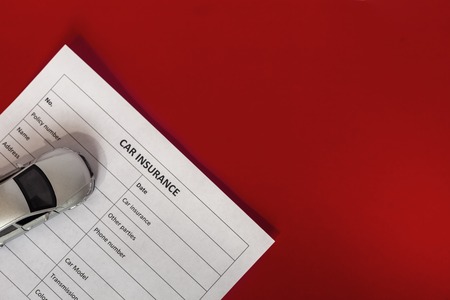 blank motor insurance document with toy car modelの写真素材
