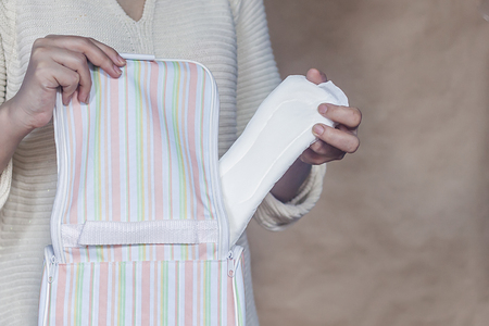 Women hold a menstrual pad. Young woman taking out a sanitary pad from her bag. White menstrual pad. Sanitary woman hygiene.の写真素材