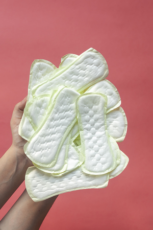 Woman holding a lot of panty liners on the pink backgroundの写真素材