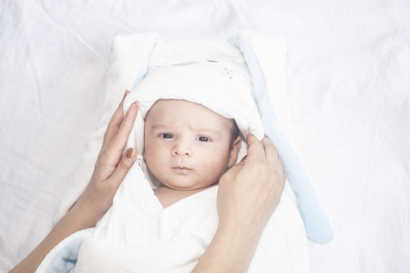 Adorable cute newborn baby boy on white background. The lovely child wore on rabbit costume with long ears. Holiday, Easter, childhood concept.の写真素材