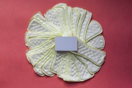 Feminine hygiene pad with blank white paper on red background.の写真素材