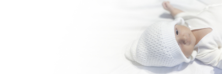 Newborn Baby Boy in Knit Hat Peacefully Lying on white backgroundの写真素材