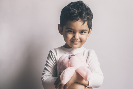 Portrait of 4-5 years adorable old boy playing with soft plush cute rabbit bunny toyの写真素材
