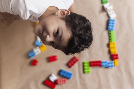 Portrait of 4-5 years adorable old boy playing with plastic brick toysの写真素材