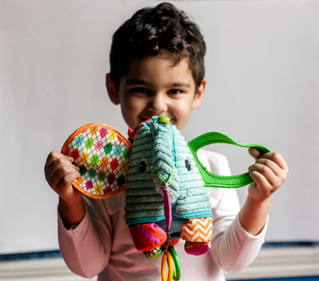 Portrait of 4-5 years adorable old boy playing with soft plush cute elephant toy