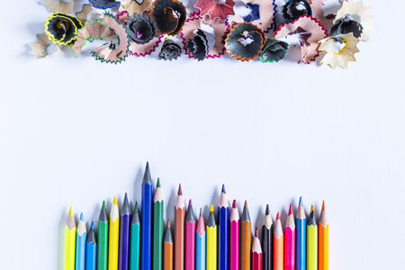 Colored pencils and trash on the white paper background. Free spaceの写真素材