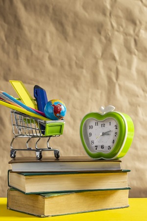 Back to school concept. Stack of books with school supplies in shopping cart.の写真素材