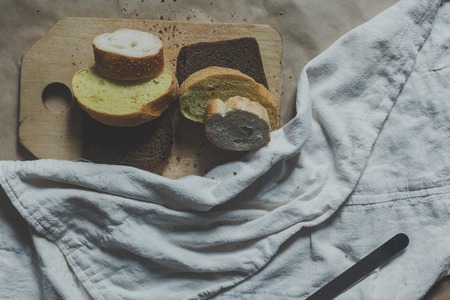Food concept. Hand cutting bread. Slicing a bread. Top view. Copy spaceの写真素材