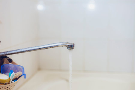 Bathroom. Open bath water tap with running water. water tap