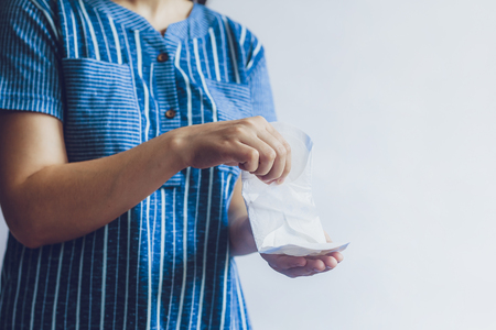 Young woman holding sanitary napkins. Period days concept showing feminine menstrual cycle.の写真素材