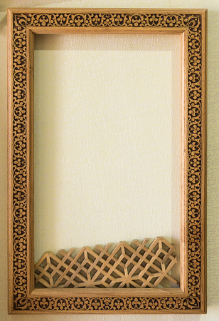 Wood frame on the wall. Wooden frame with middle eastern ornament decorations hanging on the wallの写真素材