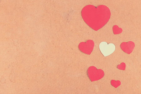 valentines day crafts for kids. Seven red and one white hearts on wooden background. Toned.