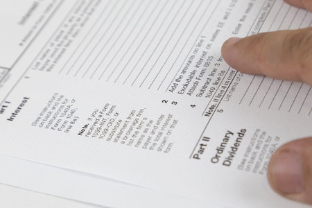 Tax concept. Man looking through US tax form with hands.
