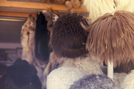 Natural fur hats. Handmade wool fur headdress shop bazaar in Bukhara, Uzbekistan. Selling group of different winter fur hats for women and menの写真素材