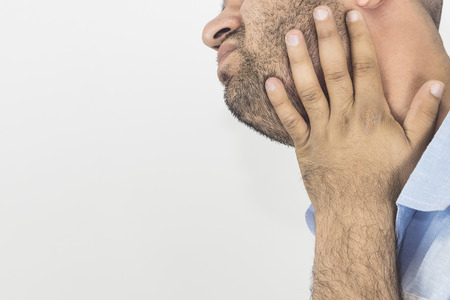 Adult male scratching beard on white backgroundの写真素材
