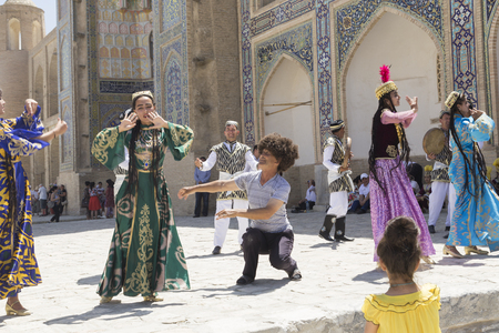 BUKHARA, UZBEKISTAN - MAY 25, 2018: Silk and Spices Festival 2018. Bukharian musicians in local dress dance, in Bukhara, Uzbekistanのeditorial素材
