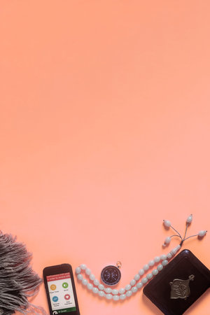 Traditional muslim prayer set bundle. Praying carpet, rosary beads, little version of the Holy Quran and qibla compass on wooden background. Copy Spaceの写真素材