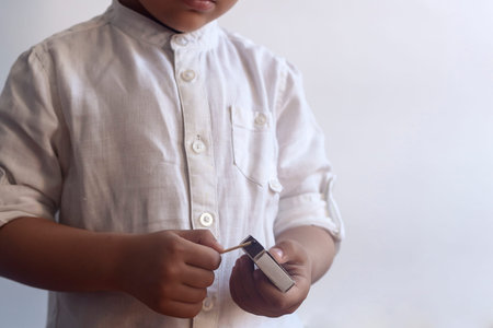 5-6 years old boy playing with fire. Middle eastern kid exploring fire. First tries of a child to...
