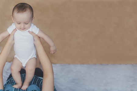 Mother and baby. Mom holding her 6 months baby boy. Beautiful baby boy of six months in his mother's hands. Young middle eastern mother holding in her arms her little son. People, family concept.の写真素材