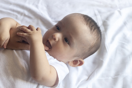 Baby teething. Baby tooth care concept. Mother checking her baby boy mouth. First signs of baby teeth come in. Infant teething pain. Free spaceの写真素材