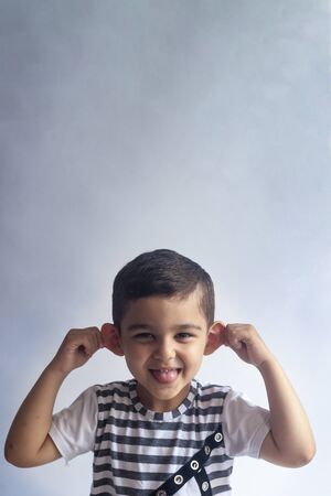 Six years boy portrait. Innocent smiling little boy on grey background. Little kid having fun. People, childhood lifestyle concept.の写真素材
