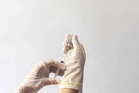 Hand with glove holding syringe with a medicine. Syringe in hand.の写真素材