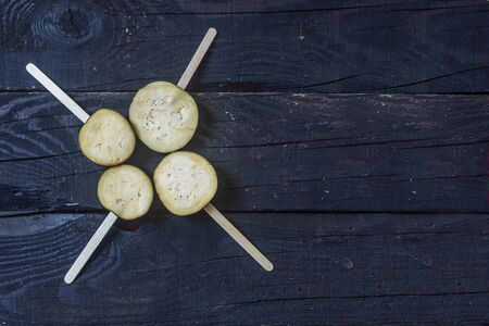 Sliced eggplants with sticks on dark rustic wooden backgroundの写真素材