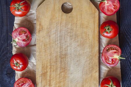 Salad ingredients. Fresh raw vegetables on wood. Cutting board with a kitchen knife. Group of omatoesの写真素材