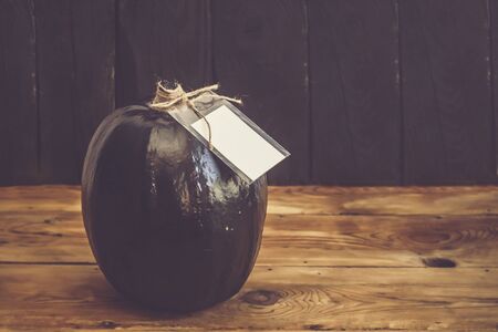 A big black pumpkin with an empty white tag. Autumn pumpkin decorated with sale tag. Fall, Halloween and Thanksgiving concept. Copy spaceの写真素材