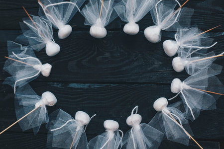 Group of decorative Halloween ghosts sticks on dark wooden background. Copy space for text....