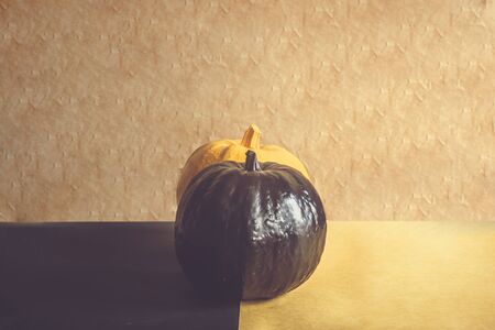 Half view of two pumpkins. Orange and black pumpkins decorated for Halloween celebration. Fall, Halloween and Thanksgiving concept. Copy spaceの写真素材