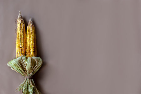 Corn bouquet on craft paper background. Bouquet made with partially shucked sweet corns with cobs....