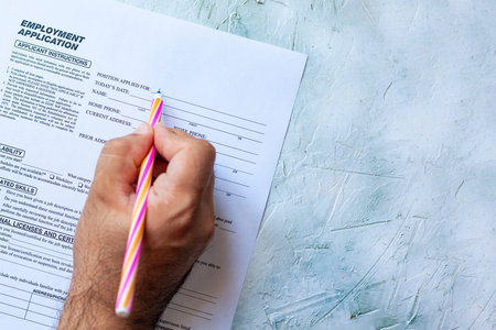 Hand filling Standard Application for Employment. HR, Hiring, Applicant Filling job application. HR, Hiring, Applying concept. Top viewの写真素材